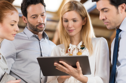 Maberry Consulting: Business people standing in the office and looking at a digital tablet. Businesswoman holding tablet