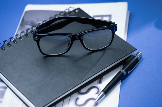 Notebook with glasses and pen