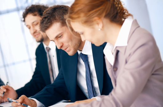 Group of business people working on documents at the office.